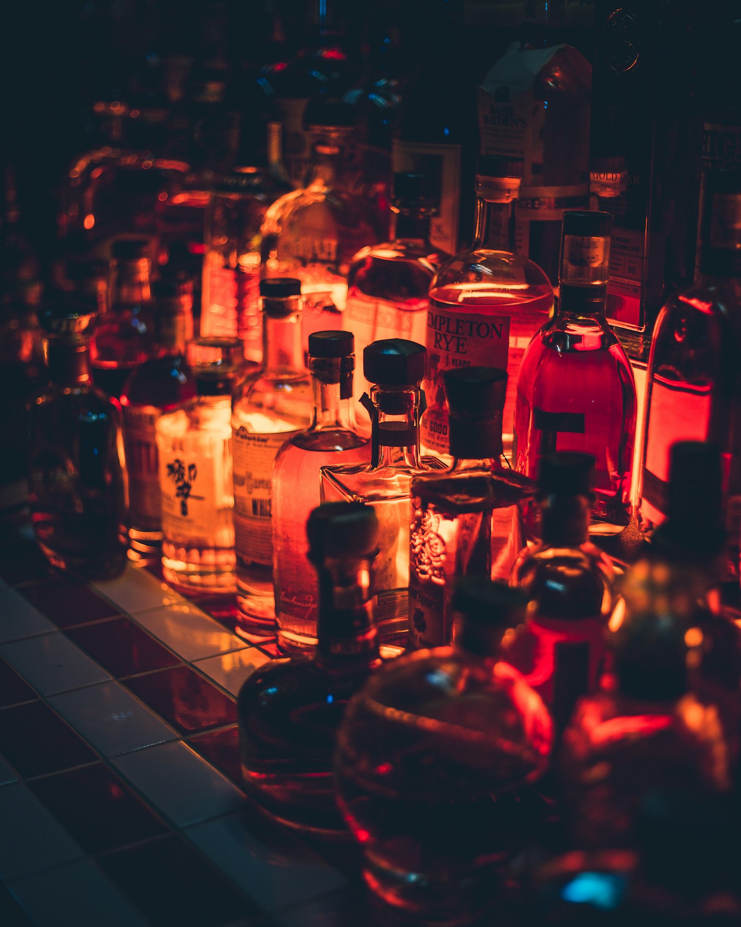Backbar lined with bourbon and whiskey bottles, lit warm