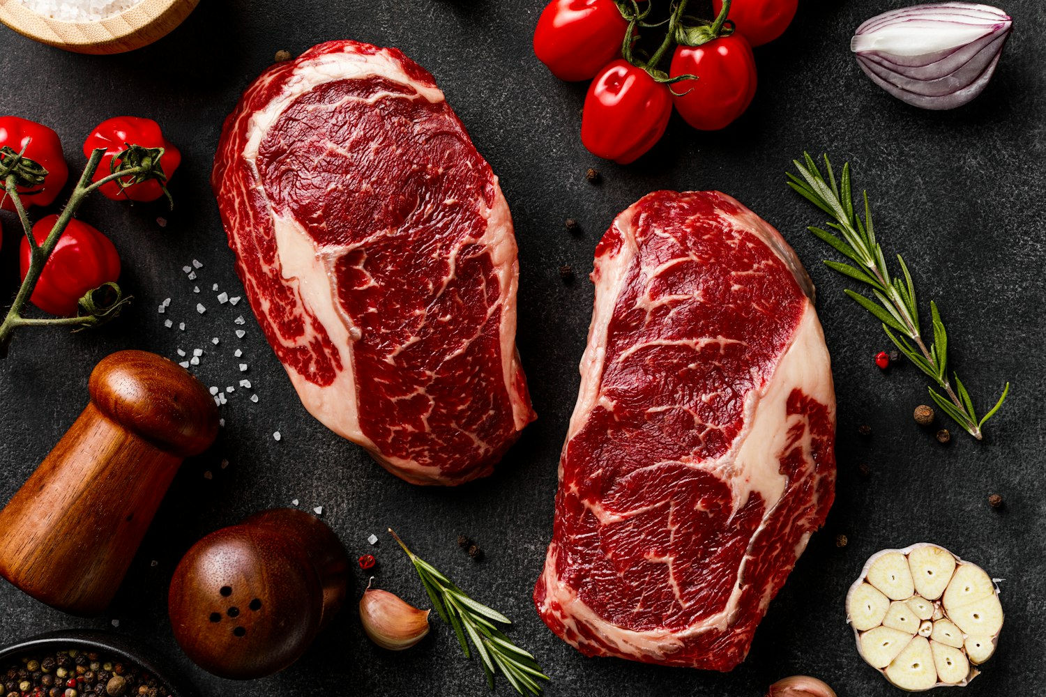 Marbled ribeye steaks hand-cut and seasoned